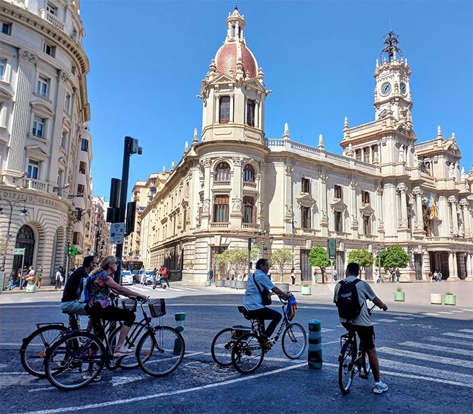 Cycling as a more eco friendly way to get around several people on bicycles in front of historic city buildings