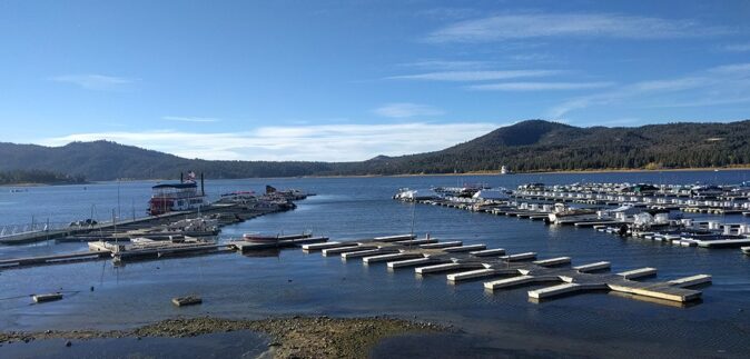 Things to do in Big Bear - water sports Docks on a lake with several boats, and mountains in the background