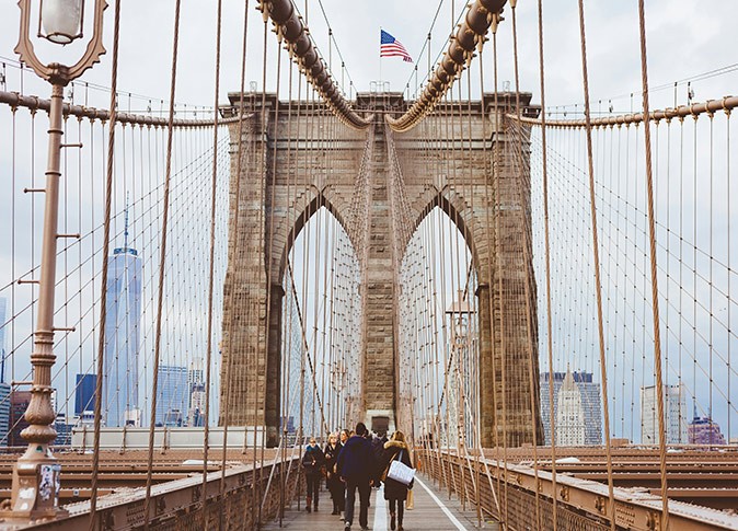 people walking across the Brooklyn Bridge