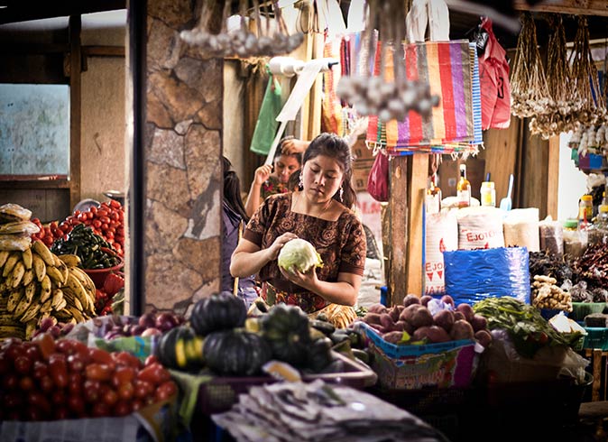 a local woman holding a cabbage at a market in Chichicastenango