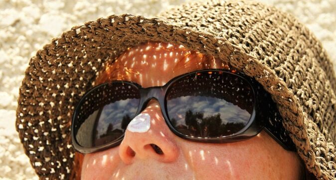 always wear sunscreen when traveling in Sydney a woman wearing sunscreen in Sydney