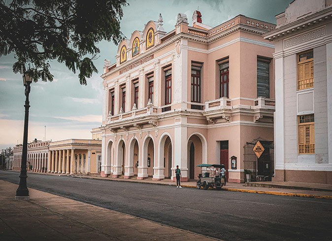 Historical sites in Cuba to visit A street with 1 tree and several well maintained historical buildings in light colors