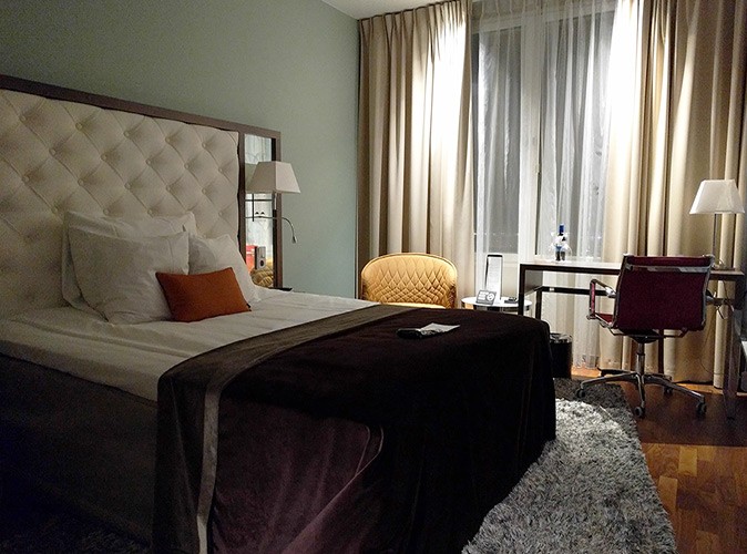 How to choose a hotel room A large, luxury hotel bed with a large window and a desk in the background