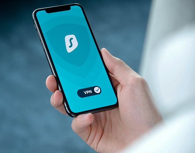 A hand holding a phone with a VPN on the screen