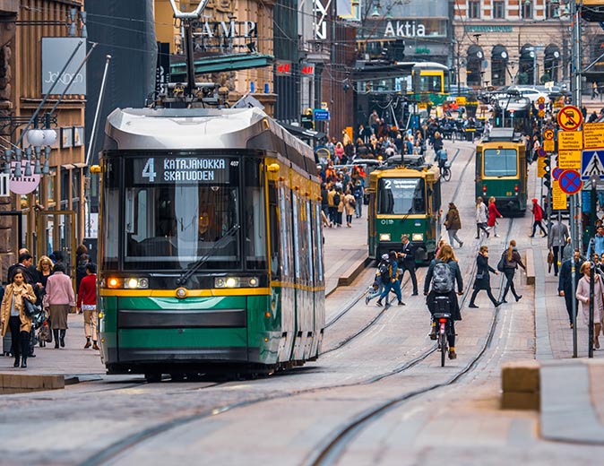 Life in Helsinki 3 trams and several people on a shopping street in Helsinki