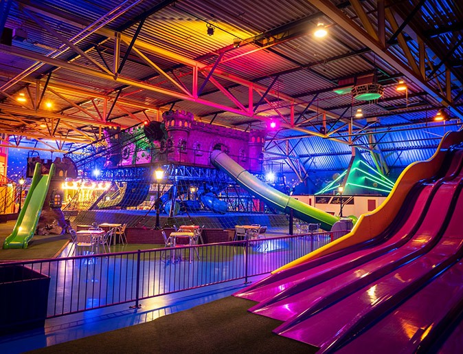 Indoor activities in Utrecht for kids A colorful indoor play area with slides, climbing structures and a few tables and chairs