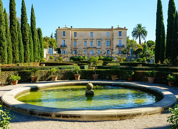 Things to do in Montpellier away from the main tourist spots A large brown and beige house with elaborately landscaped gardens and a large fountain