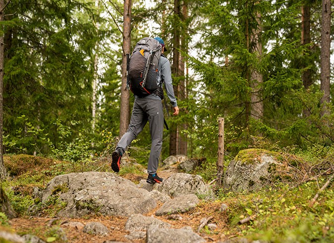 Things to do in Vaasa for outdoor lovers A man with a backpack hiking through a forest