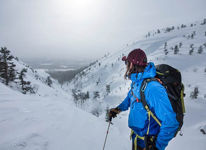 Pyhä, one of the best places in Lapland to see northern lights a man in a bright blue coat skiing in Pyhä, one of the best places in Lapland to see northern lights