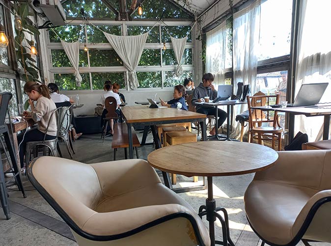 a bright and modern cafe in Chiang Mai with several people working on their laptops
