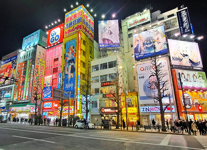 Tech things to do in Tokyo A wide road lined with highrise buildings filled with signs advertising tech and nerdy brands in Tokyo
