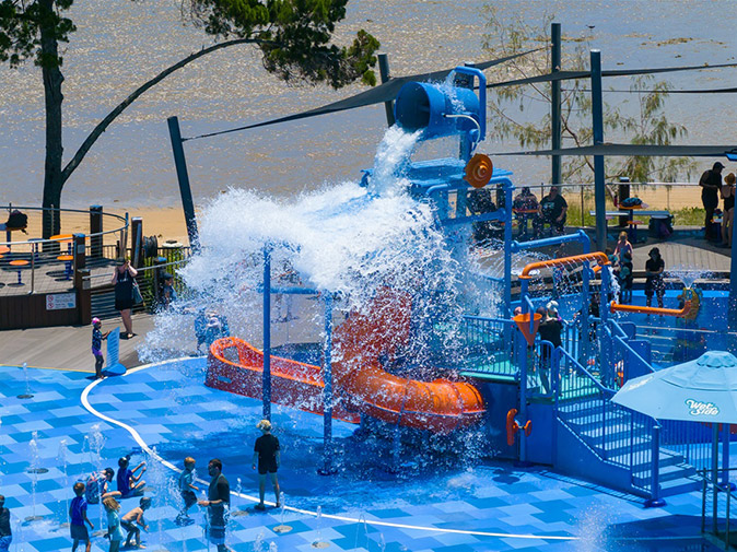 What to do in Hervey Bay for free A water park showing orange and blue slides, lots of water and some kids playing