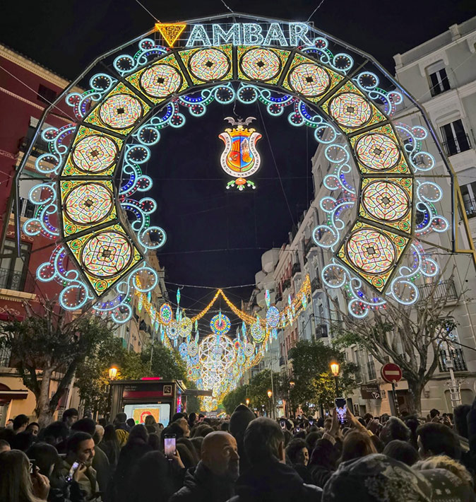 One of the events at las Fallas de Valencia A crowd of people in a street decorated with a lot of lights
