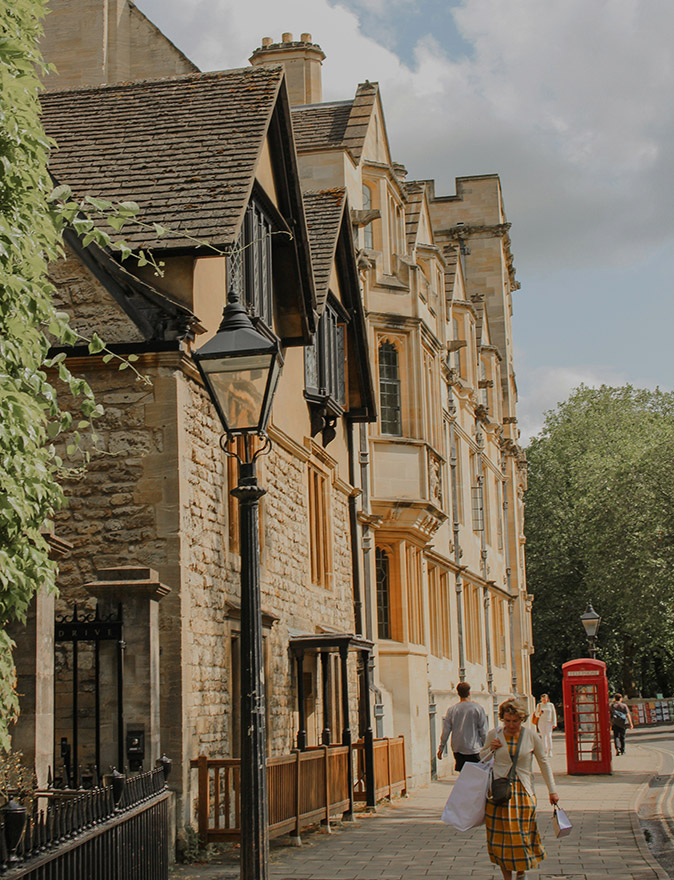 Moving to Oxford, UK Stone buildings, a traditional red British phone booth, and a few pedestrians