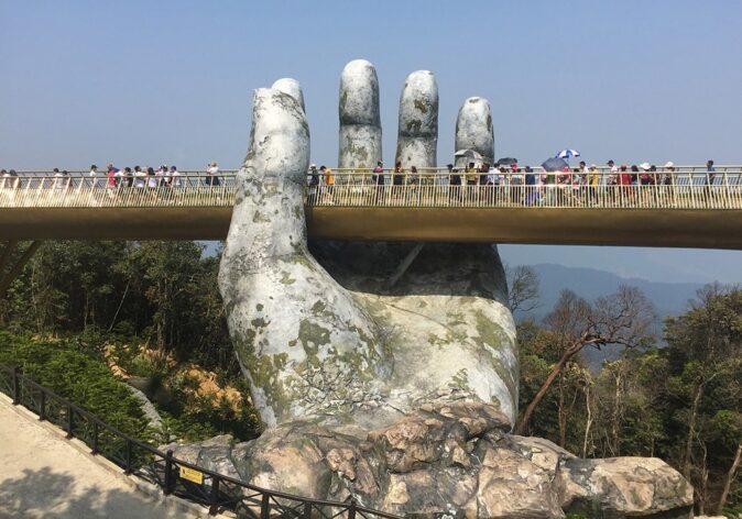 The famous Golden Bridge at Ba Na Hills - 2 Days in Da Nang A giant concrete hand supporting a bridge with several people