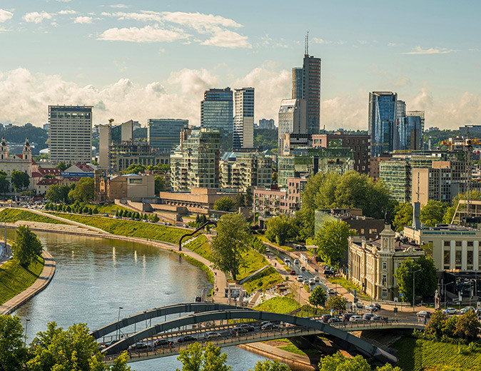 Vilnius, a good place to live Aerial view of a city skyling with a wide river, a modern bridge, modern highrise buildings and some greenery