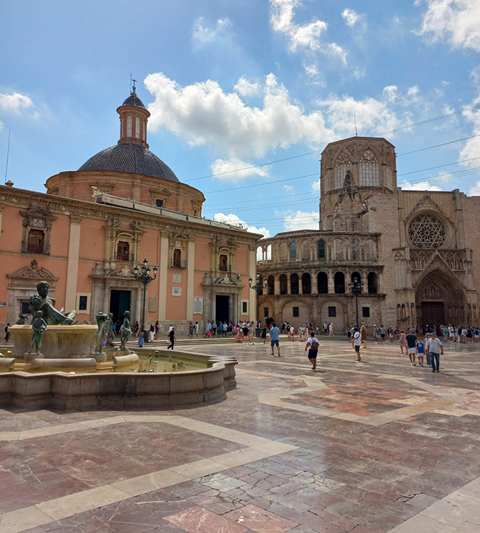 Valencia, Spain for retirement A city square in Valencia with a large fountain and a historic cathedral