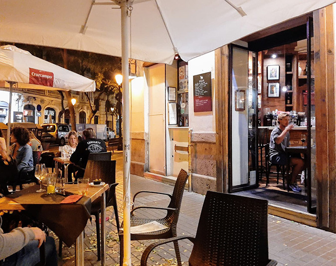 One of the nicest tapas bars in Valencia A terrace with several people looking towards the entrance of a cozy tapas bar