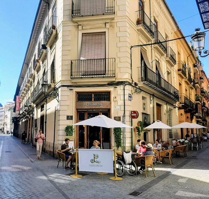 One of the best tapas bars in Valencia's Old Town Exterior of a tapas bar in the old town of Valencia showing a historic building and several people on a terrace