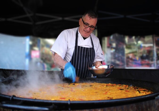 a giant paella in Spain a man cooking a giant paella