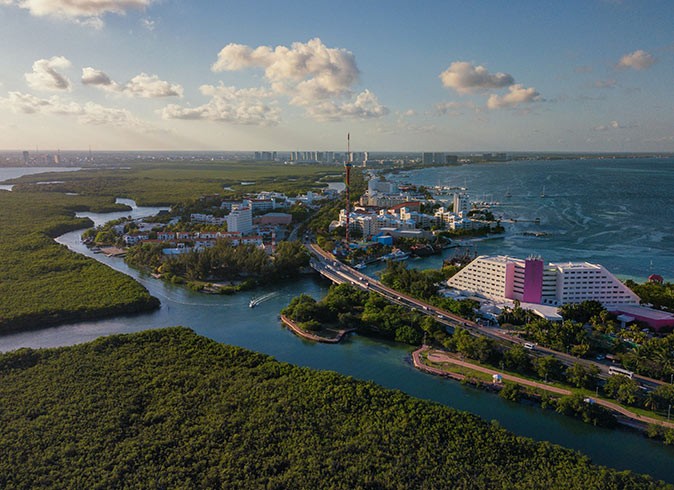 expat life in Cancun, Mexico Aerial view of a coastal area with high rise buildings, greenery and rivers
