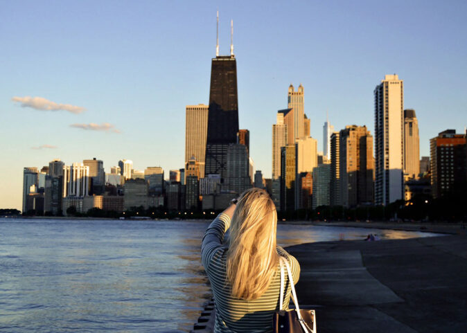 woman taking a picture of Chicago's skyline woman taking a picture of Chicago's skyline