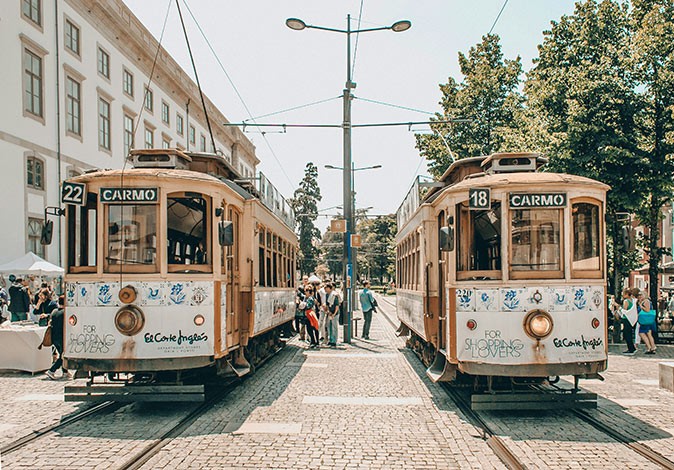 Life in Porto 2 classic trams with people getting on and off them