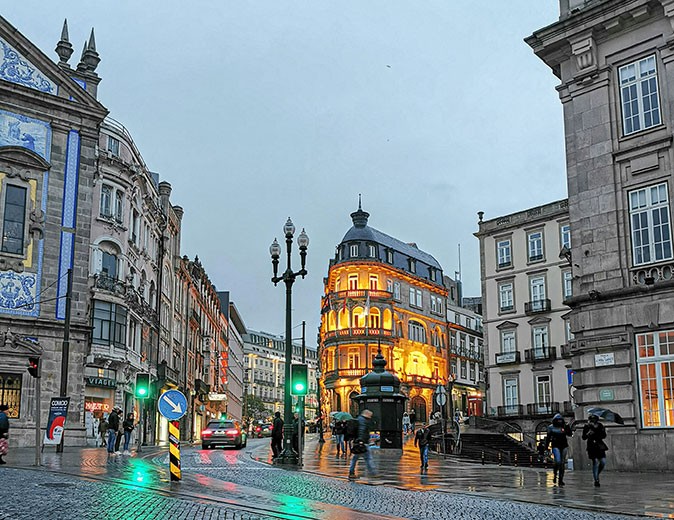 Expat life in Porto, Portugal A typical Southern European city street around sunset with historic buildings and traffic