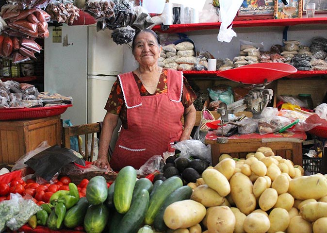 a woman selling vegetables at a Mexican market a woman selling vegetables at a Mexican market