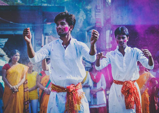 celebrating Holi in India two boys celebrating Holi in India, with a crowd in the backgrouns