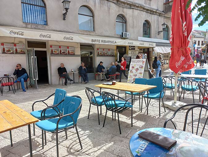 the terrace of a cafe in Mostar with several local men sitting at tables