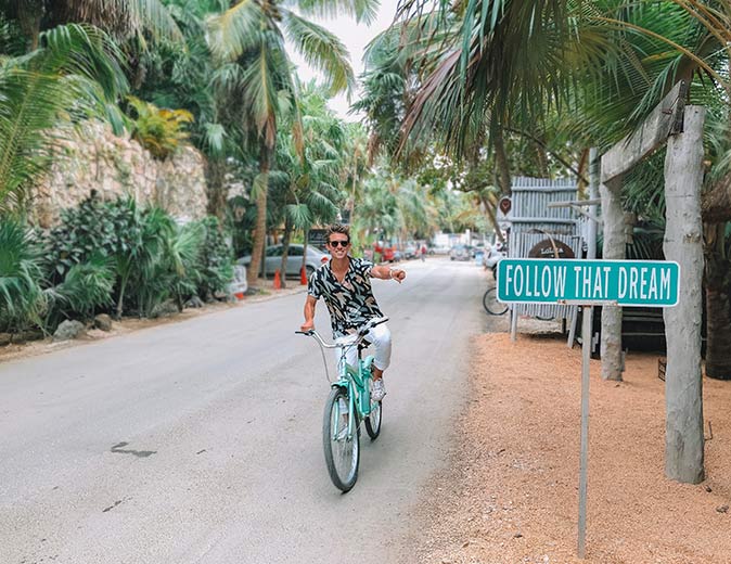 a man on a bicycle in the center of Tulum