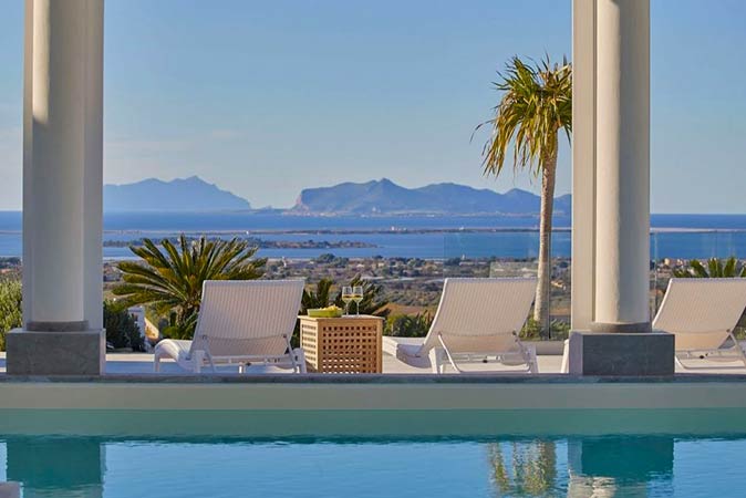 Staying in Marsala to explore the most beautiful places in Sicily the pool and sun loungers of a villa in Marsala, rented to explore the most beautiful places in Sicily