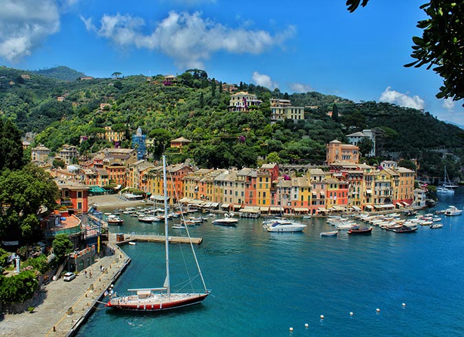 colorfull houses around a small port filled with boats on a sunny day