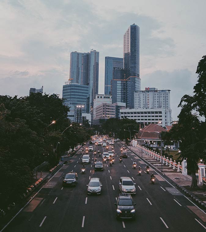 Surabaya, one of the Indonesian cities that has a sizeable expat community the modern skyline of Surabaya in the background with a wide road with a lot of cars in the foreground