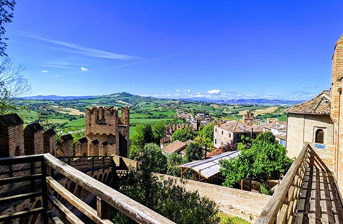Gradara, one of the most beautiful small towns in Italy a view from the Gradara castle to the surrounding countryside with several houses, green fields and a blue sky
