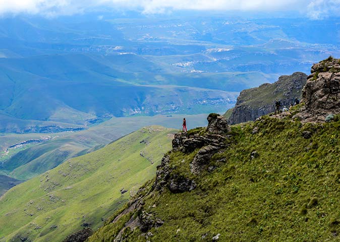 a person stainding on the edge of a cliff in the Drakensberg Mountains