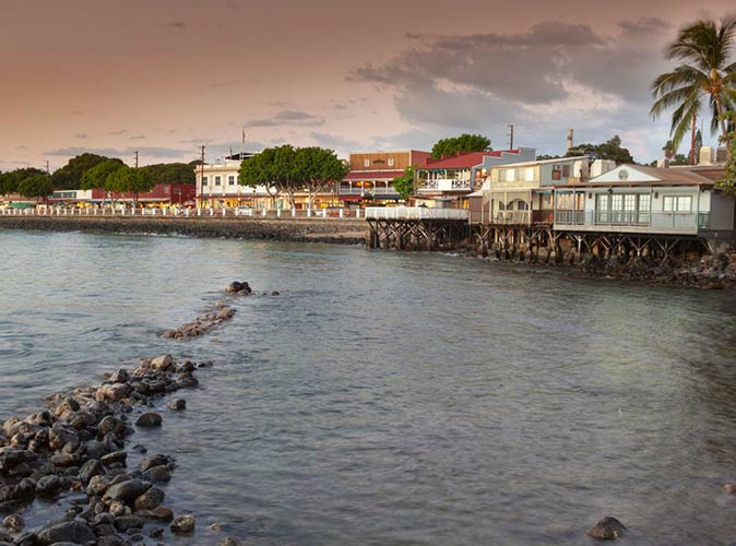 a view across the water during sunset towards a row of houses