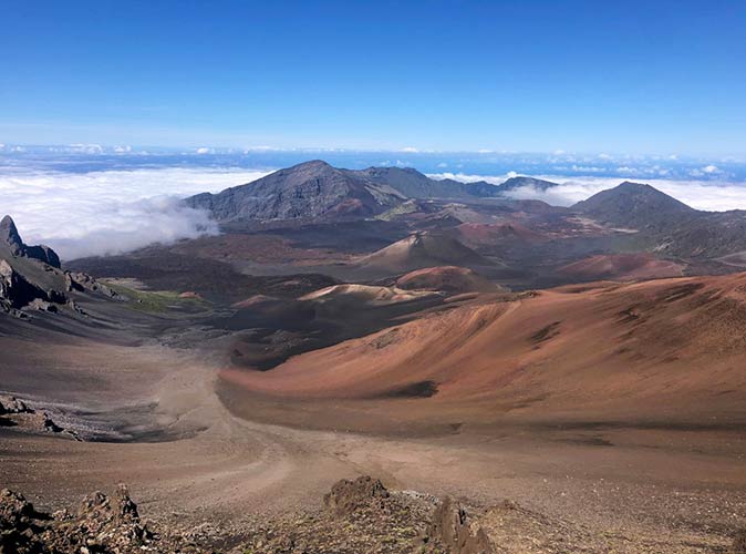a dry, mountainous landscape surrounded by clouds, without people