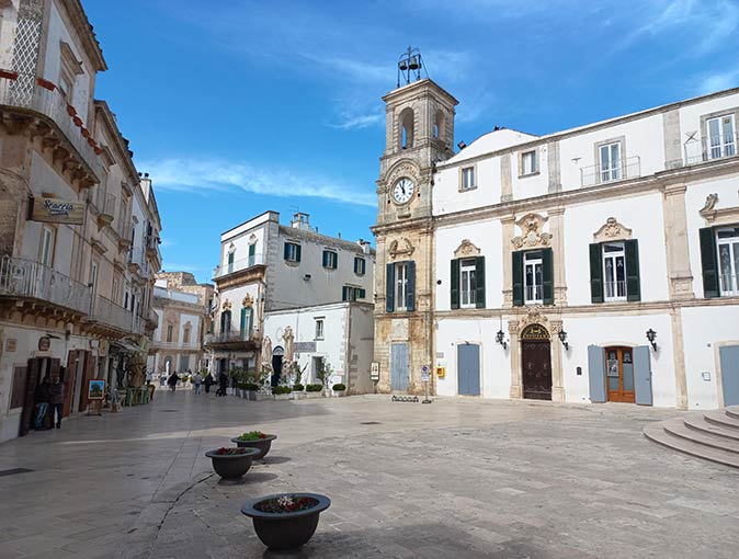 a church square surrounded by historic buildings in a typical Puglian town