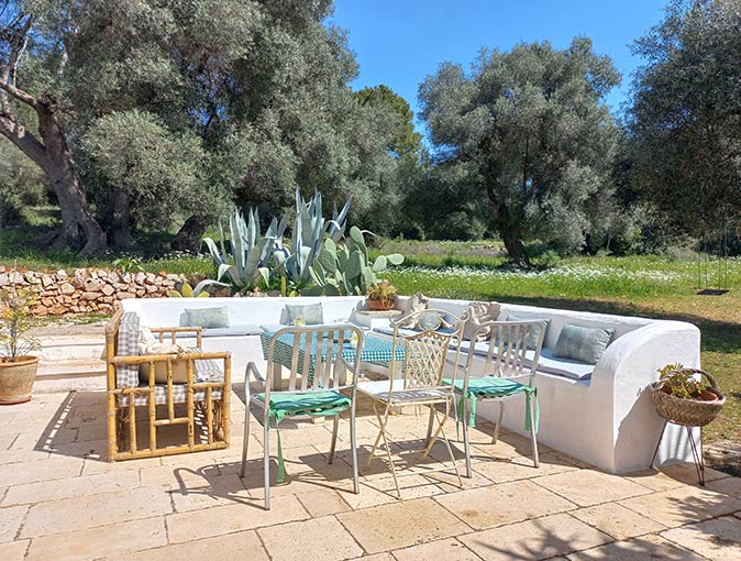 an outdoor seating area surrounded by cacti and trees