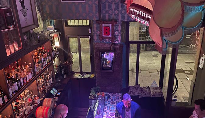 a dark cafe with a lot of bottles of spirits on the wall