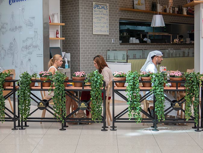 a small restaurant with 2 women sitting on one table and one man on the next table