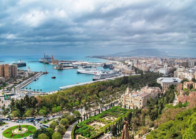 an aerial view of the coastal city Malaga with a cloudy sky