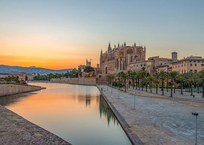 brown buildings with water in front of it at sunset