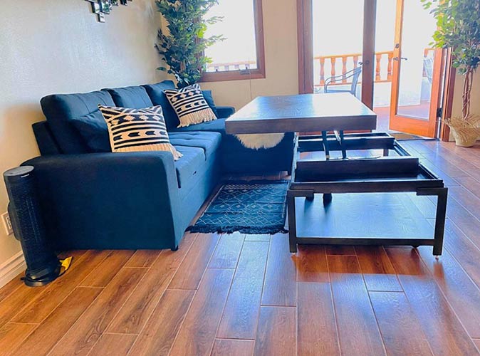 a living room with a couch, a table and large windows