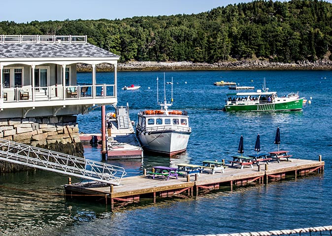a harbor with a dock, several boats and a wooden house