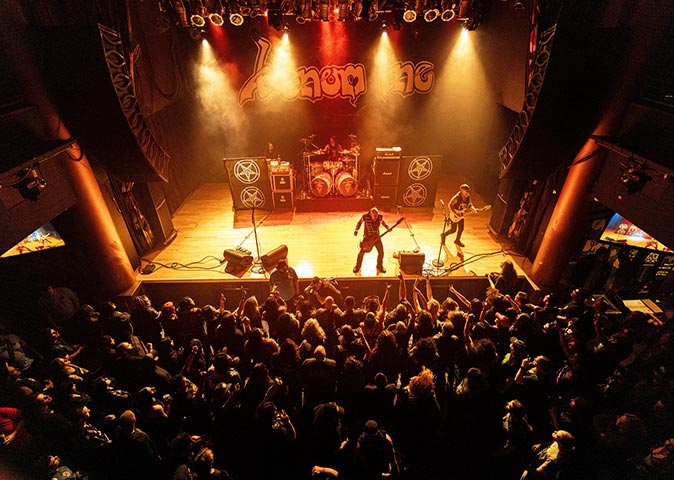 two musicians on stage with a large crowd watching them