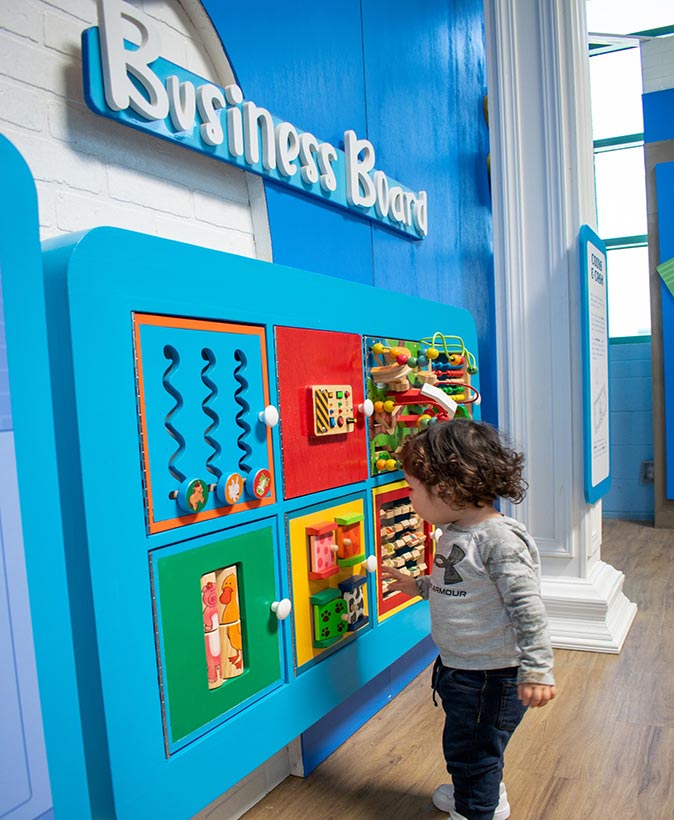 a young girl playing games that are fixed to a wall
