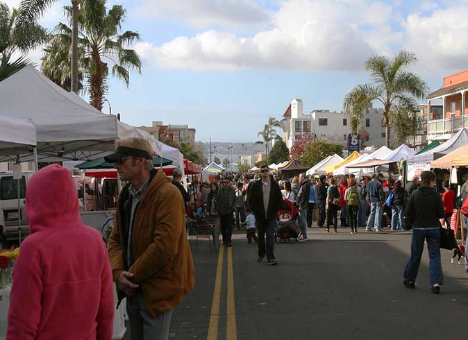 several market stands and a lot of people at a Farmers' Market in San Diego